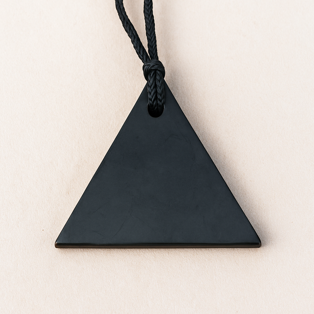 Black triangular Shungite pendant with visible string hole, shown on a plain background to highlight its polished finish and sleek design.